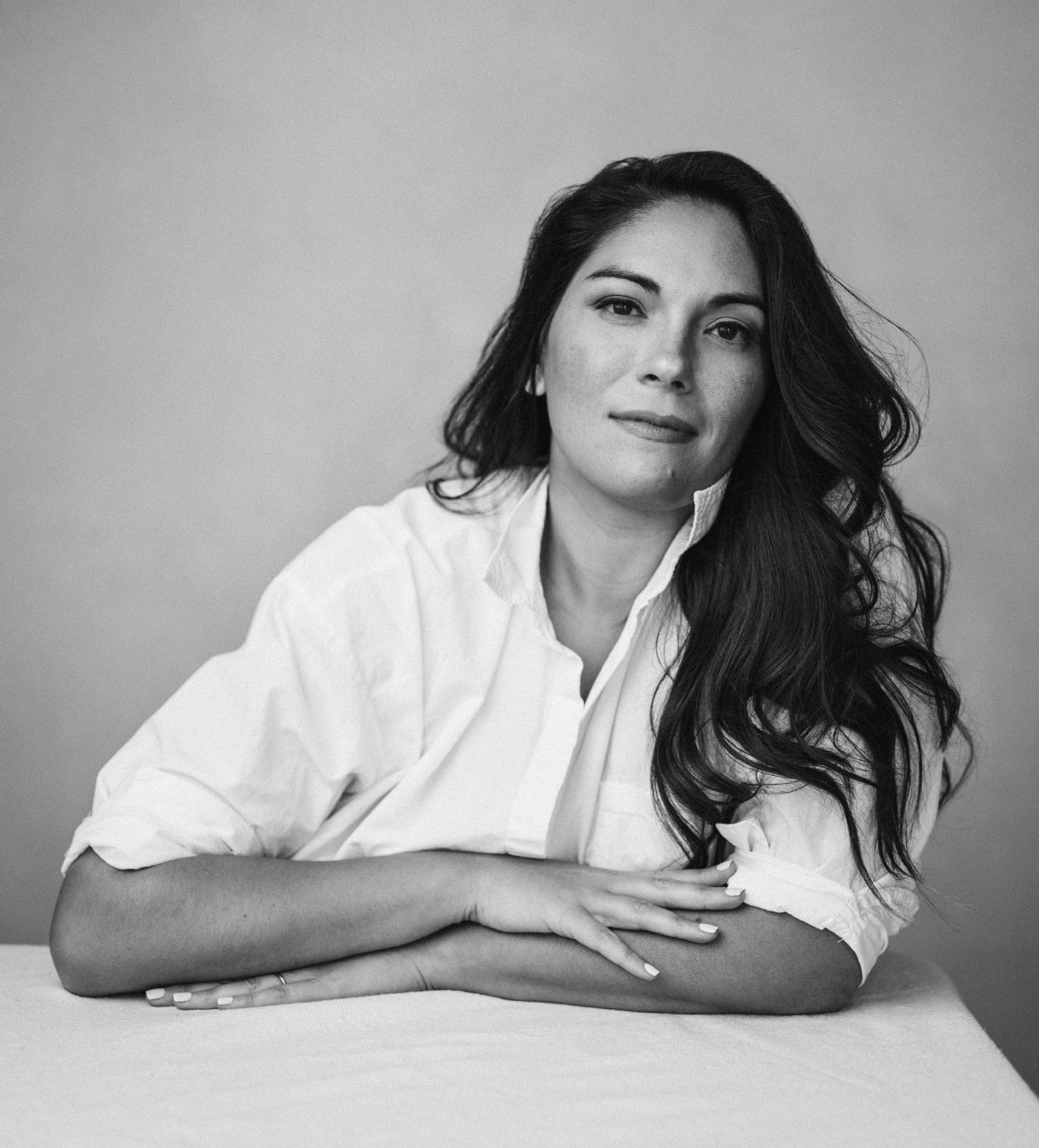 Black and white portrait of Tiffany Harlan with long hair wearing a white shirt.